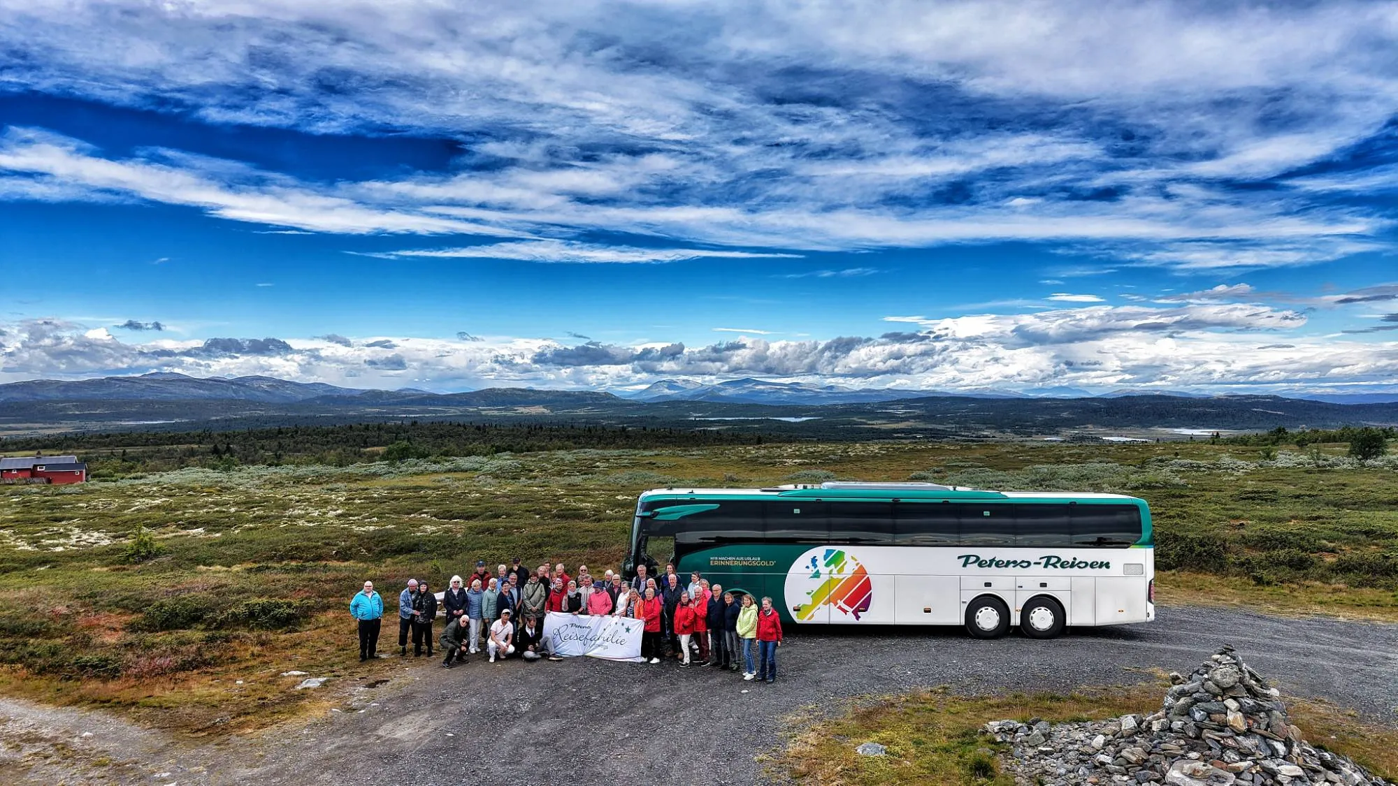 Reisegruppe der Peters-Reisefamilie vor dem Bus in den Bergen Norwegens