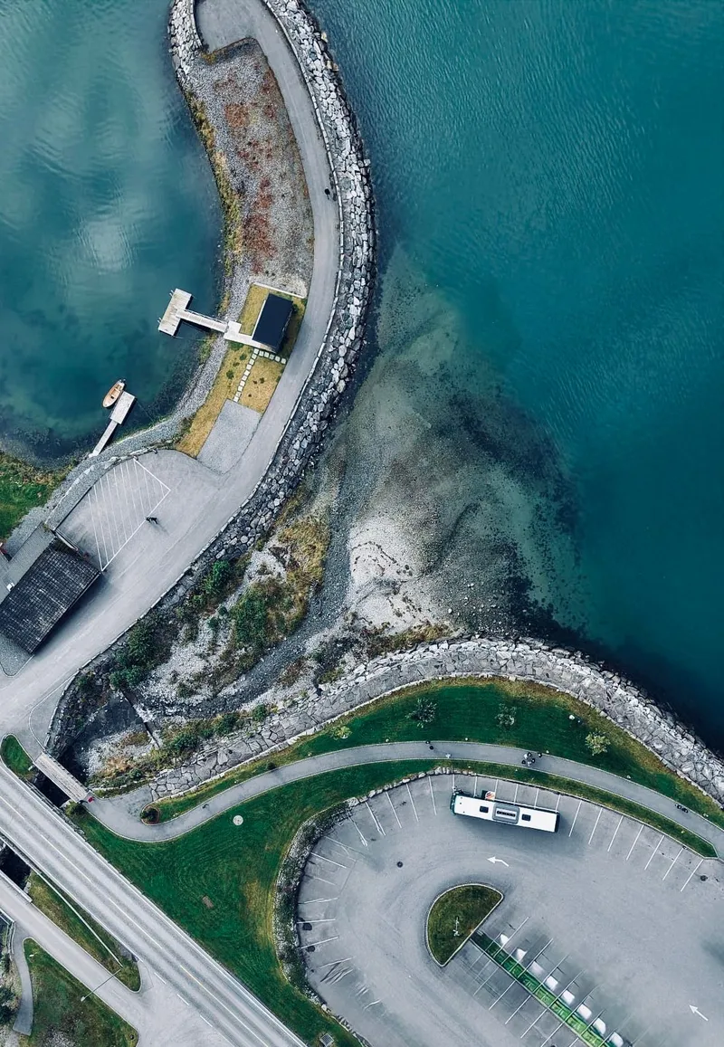 Peters-Reisen Bus auf einem Parkplatz am Fjord, Luftaufnahme